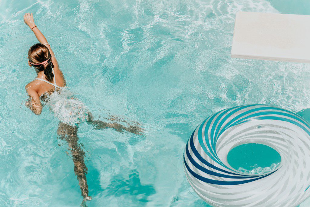 girl swimming in pool with inner tube