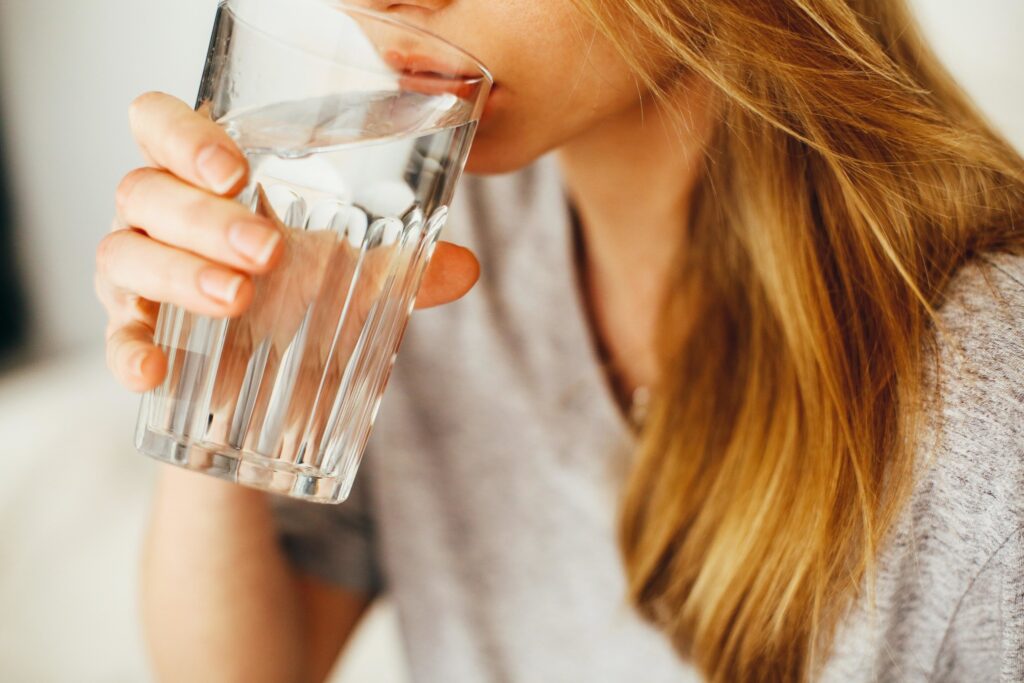 woman drinking water from glass