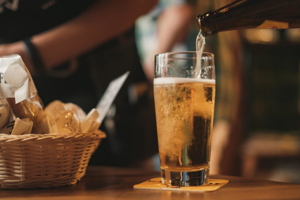 beer being poured into glass cup