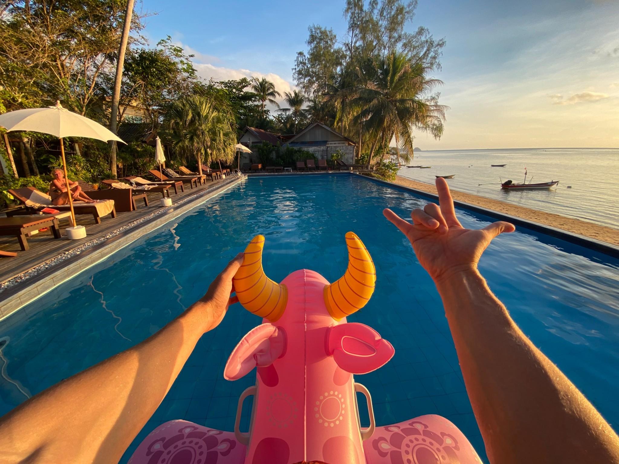 person lying on pink inflatable inflatable float on swimming pool during daytime