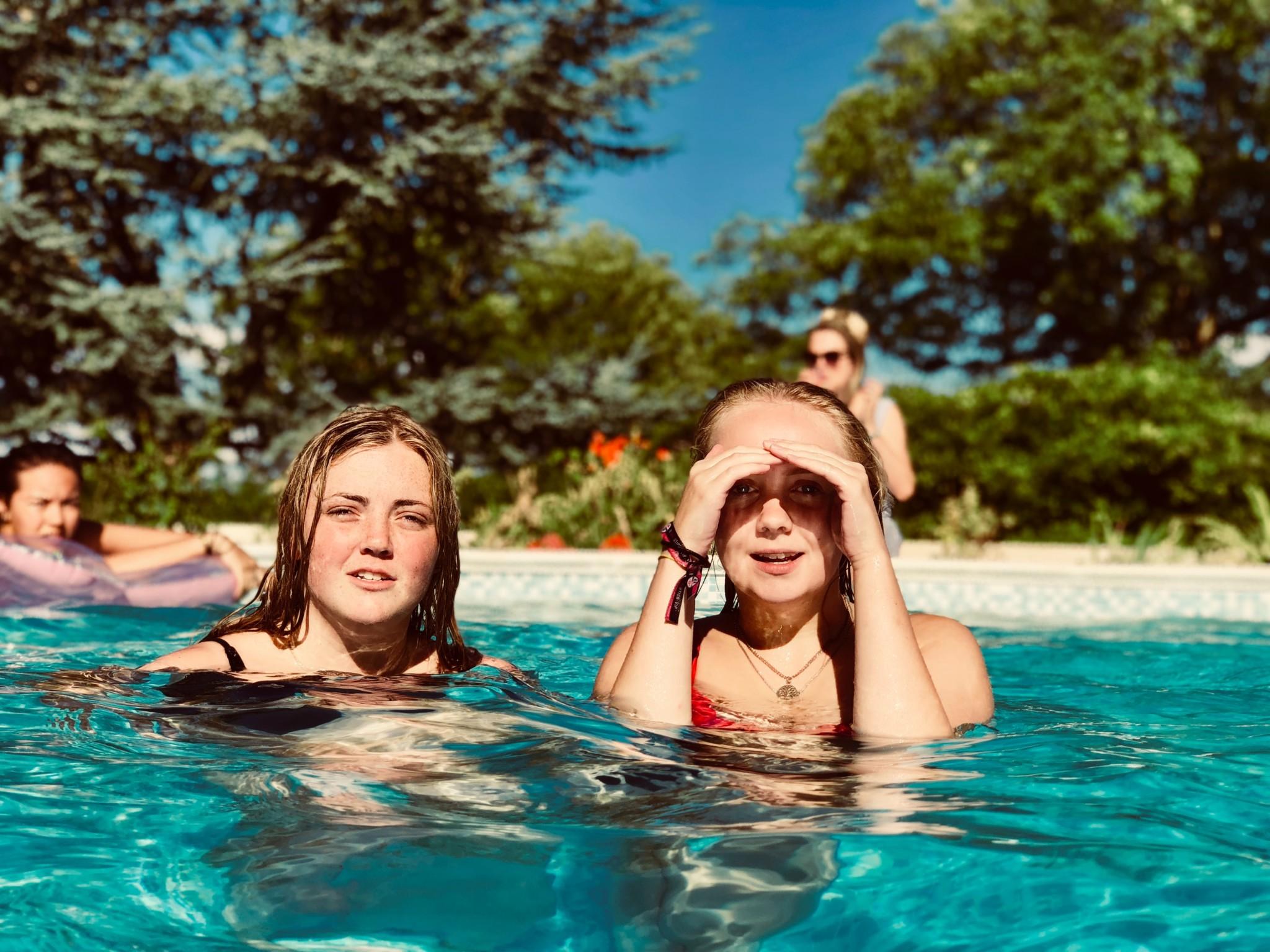 two girls in pool bright sun